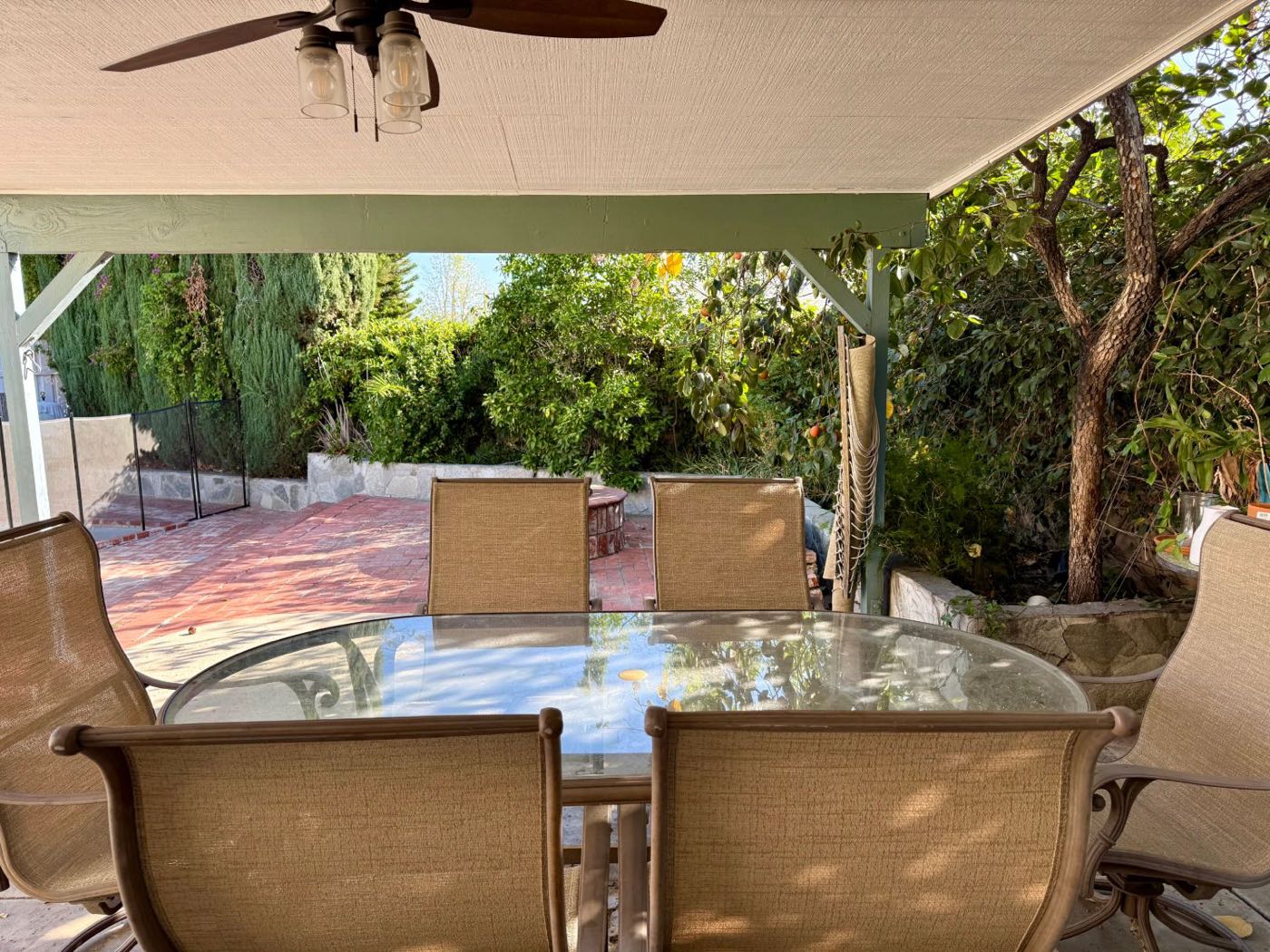 The covered patio, with a table and chairs looking out on a green garden